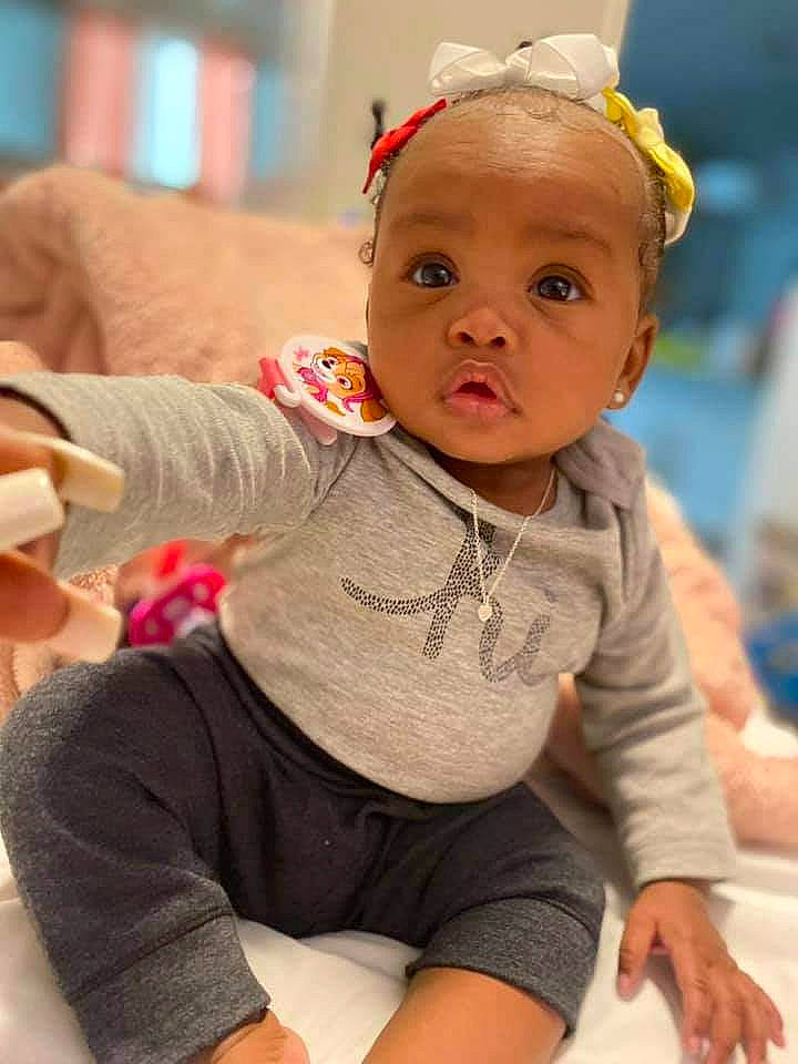 Ledarriona is registered to the contest to win money with this photo: arm, baby, baby_toddler_clothing, cheek, child, face, fashion_accessory, finger, flooring, fun, happy, headband, headgear, leisure, person, sitting, skin, sleeve, sock, t_shirt