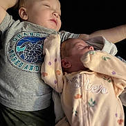 Austin Jr joined the competition — help win amazing prizes! arm, baby, black_background, blanket, camouflage_pants, cozy, face, graphic_tshirt, head, indoor, infant, newborn, onesie, portrait, sibling, sleeping, soft_lighting, t_shirt, toddler, turtle