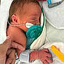 Nyla is registered to the contest to win money with this photo: baby, newborn, infant, pacifier, nasal_tube, medical_tube, hospital, swaddle, sleeping, hand, adult_hand, tiny_fingers, monitoring_device, blanket, adhesive_tape, neonatal_care, medical_setting, close_up, delicate_skin, healthcare