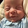 Baylor is registered to the contest to win money with this photo: baby, smiling, sleeping, blue_onesie, blanket, face, infant, cute, cozy, portrait, newborn, child, soft_lighting, indoors, closeup, peaceful, happy, tiny, resting, human