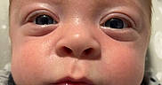 Baylor is registered to the contest to win money with this photo: baby, infant, face, closeup, polka_dot, clothing, cute, child, eyes, chubby_cheeks, portrait, young, expression, skin, head, newborn, person, soft, blanket, sleepwear