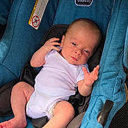 Baylor joined the competition — help win amazing prizes! baby, infant, car_seat, blue, white_onesie, child, newborn, skin, hand, foot, seatbelt, fabric, portrait, cute, small, relaxing, indoors, person, sitting, comfort