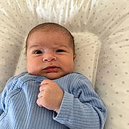 Imrân participe au concours pour gagner de l'argent avec cette photo : baby, infant, blue_onesie, face, hand, cushion, pattern, star_pattern, lying_down, close_up, skin, head, expression, indoor, newborn, child, cute, portrait, soft_fabric, comfortable