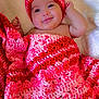 Melody Carballo Paz joined the competition — help win amazing prizes! baby, infant, blanket, crochet, hat, smile, face, cute, child, red, pink, cozy, warm, soft, fleece, lying_down, happy, closeup, headwear, portrait
