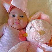 Melody Carballo Paz is registered to the contest to win money with this photo: baby, pink_bow, plush_toy, stuffed_animal, blanket, soft_texture, infant, cute, child, pacifier, ribbon, headwear, portrait, indoors, cozy, sleepwear, toddler, face, cuddly, pink_clothing