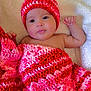 Melody Carballo Paz is registered to the contest to win money with this photo: baby, infant, blanket, crochet, hat, red, pink, cozy, cute, child, portrait, lying_down, soft, warm, face, skin, expression, indoors, resting, newborn