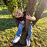 Kenneth joined the competition — help win amazing prizes! child, boy, tree, climbing, smiling, sunlight, grass, outdoor, nature, casual_clothing, jeans, sneakers, playful, happy, greenery, branches, daylight, leaves, person, fun