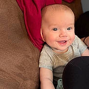 Jason is registered to the contest to win money with this photo: baby, smile, happy, couch, blanket, infant, person, indoor, portrait, clothing, hand, adult, face, head, skin, eyes, mouth, sitting, casual, comfort