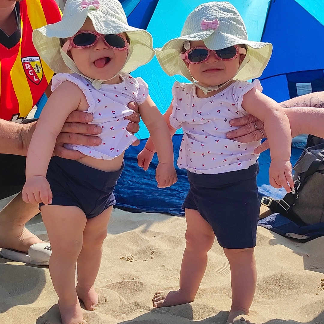 Julie Adaire participe au concours pour gagner de l'argent avec cette photo : accessories, architecture, baby, beach, building, cap, clothing, face, hat, head, outdoors, person, photography, portrait, shelter, shorts, summer, sunglasses, sunhat, swimwear