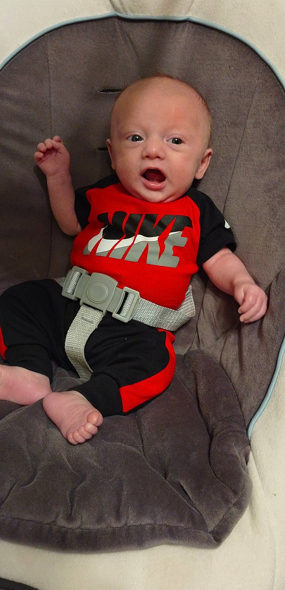 Garrett is registered to the contest to win money with this photo: arm, baby, baby_toddler_clothing, cheek, child, comfort, finger, hand, happy, human_body, knee, leg, linens, person, sleeve, smile, sportswear, surprise, t_shirt, thigh