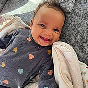 Kessy a rejoint le concours — aidez-le/la à gagner de superbes lots ! baby, babylaughing, blanket, bodypart, clothing, coat, couch, cushion, face, furniture, happy, head, homedecor, jacket, laughing, person, photography, portrait, quilt, smile