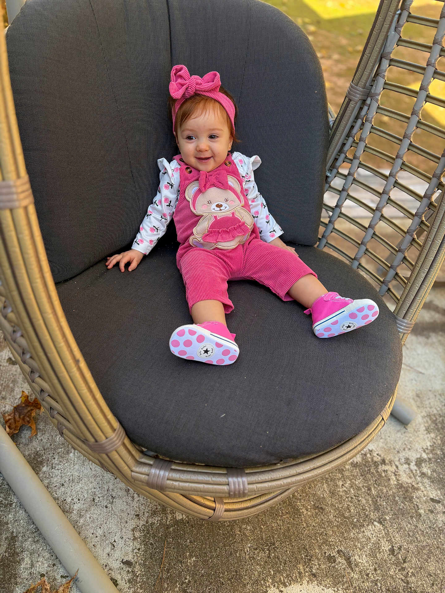Karol joined the competition — help win amazing prizes! baby, child, girl, smiling, pink_outfit, headband, wicker_chair, cushion, outdoor, sunlight, happy, feet, shoes, concrete, leaves, playful, young, portrait, seated, casual