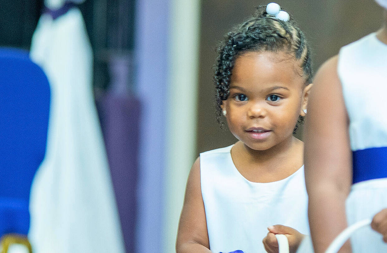 Bria is registered to the contest to win money with this photo: black_hair, blue, child, ear, event, eyelash, fun, gesture, happy, headpiece, jewellery, leisure, person, room, smile, t_shirt, toddler, tradition