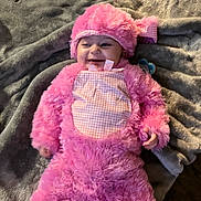 Zoey joined the competition — help win amazing prizes! baby, pink_costume, smile, blanket, infant, cute, cozy, child, happy, lying_down, soft_texture, headwear, cheerful, indoors, portrait, baby_clothing, baby_face, warm, pacifier, plush