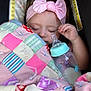 baby, sleeping, pink_bow, headband, blanket, patchwork_quilt, bottle, milk, child, infant, cute, cozy, soft_lighting, portrait, closeup, hand, car_seat, peaceful, resting, indoors
