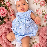 Haydee is registered to the contest to win money with this photo: baby, child, infant, portrait, smiling, happy, blue_dress, floral_pattern, headband, flower, wicker_basket, pink_blanket, roses, flowers, soft_blanket, lying_down, indoor, pastel_colors, baby_photography, cute
