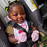 Jazmine is registered to the contest to win money with this photo: baby, child, car_seat, smile, mittens, hair_clips, camo_pants, seatbelt, portrait, happy, infant, cute, indoors, clothing, safety, young_child, person, head, face, seat
