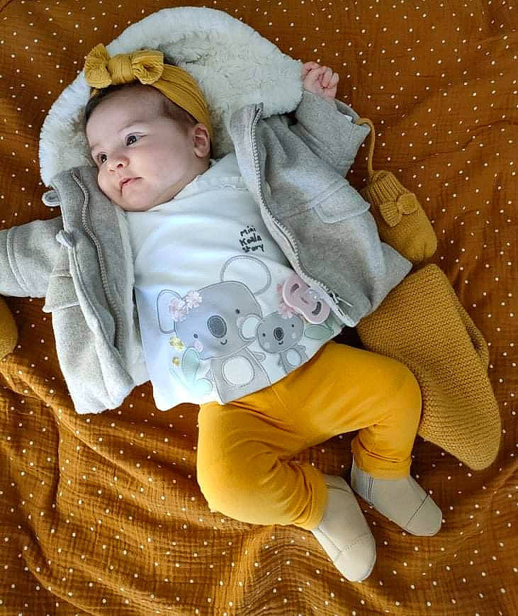 Livia a rejoint le concours — aidez-le/la à gagner de superbes lots ! baby, baby_products, baby_sleeping, baby_toddler_clothing, cheek, child, comfort, face, grass, headgear, linens, mammal, outerwear, pattern, person, sitting, skin, sleeve, textile, toddler