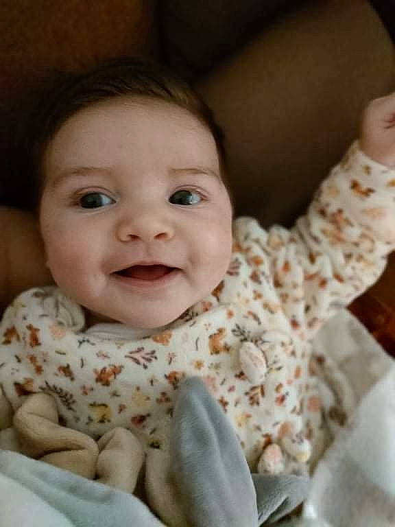 Livia participe au concours pour gagner de l'argent avec cette photo : baby, baby_toddler_clothing, cheek, child, chin, collar, dress, eye, face, finger, gesture, happy, head, iris, joy, lip, person, sitting, skin, sleeve