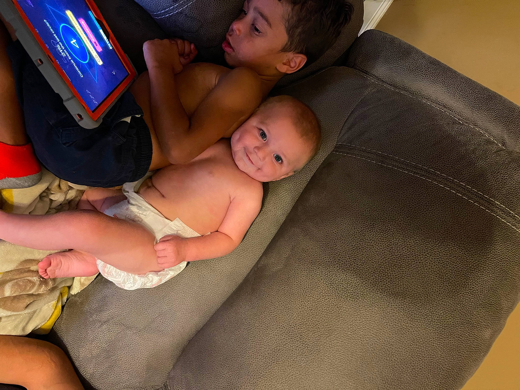 Olyver is registered to the contest to win money with this photo: abdomen, baby, chest, child, comfort, couch, eye, finger, fun, hand, human_leg, knee, lap, leg, nail, person, stomach, tablet_computer, thigh, toddler