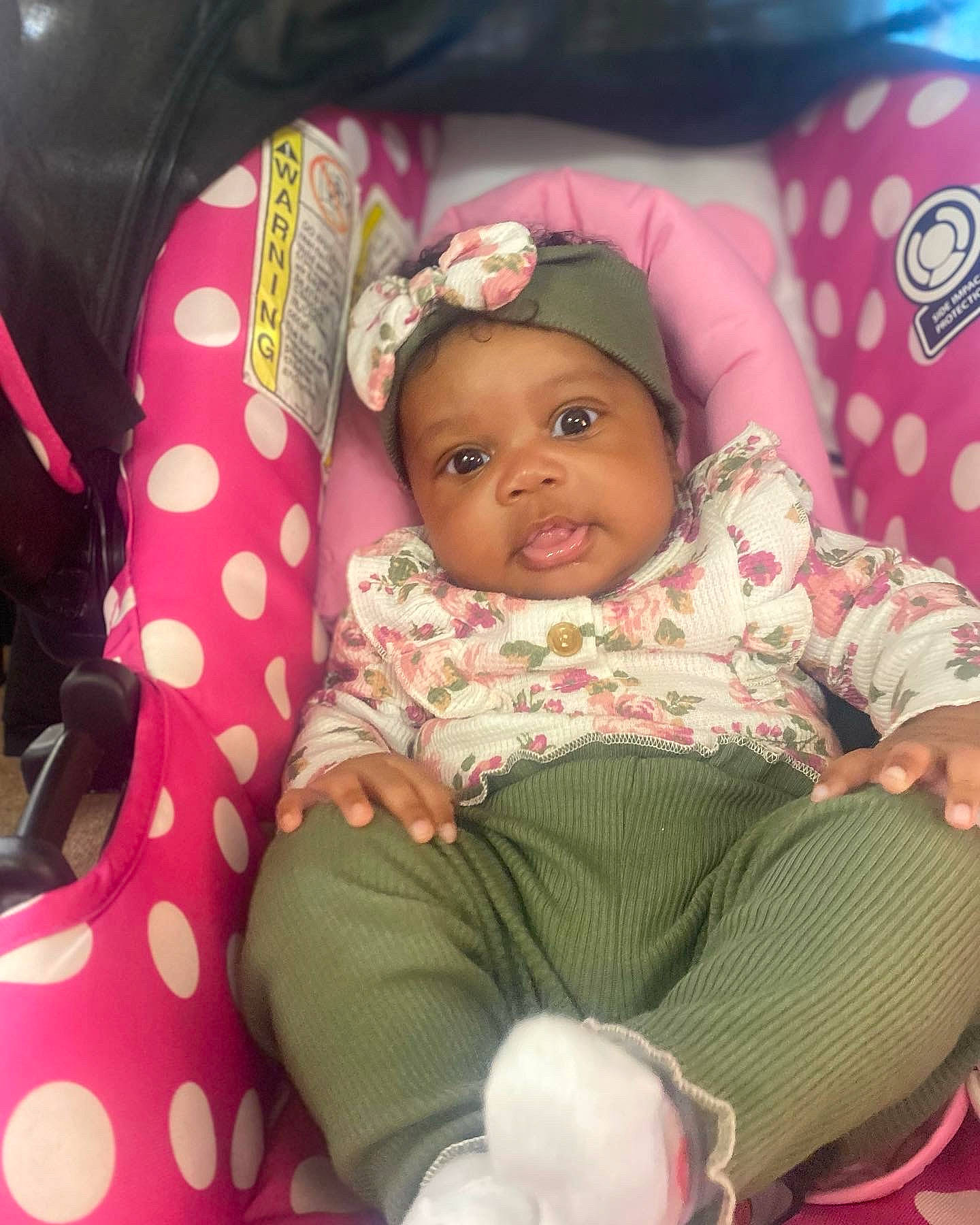 Loyalty is registered to the contest to win money with this photo: baby, baby_products, baby_toddler_clothing, cheek, child, comfort, event, eye, face, facial_expression, headwear, lap, linens, magenta, pattern, person, pink, sitting, skin, sock