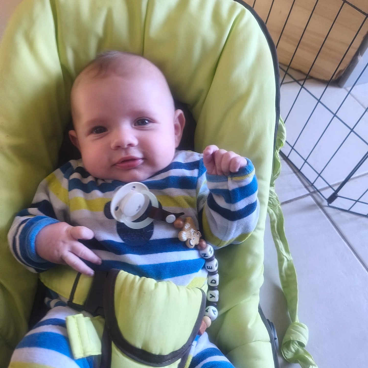 Ayden Weigel a rejoint le concours — aidez-le/la à gagner de superbes lots ! baby, bouncer, cushion, cute, eyes, face, floor_tiles, hand, head, indoor, infant, metal_grid, pacifier, pacifier_clip, playpen, seat_belt, smile, striped_clothes, striped_pajamas, toy_beads
