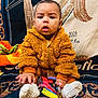 Nikko is registered to the contest to win money with this photo: baby, blanket, brown_jacket, candy, child, curious_expression, cute, fluffy_clothing, footwear, hand, hersheys, indoor, infant, lollipop, patterned_blanket, sitting, snickers, sugar_free, toy, white_socks