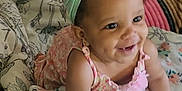 Meadow joined the competition — help win amazing prizes! baby, child, smile, dimple, headband, bow, floral_dress, blanket, pattern, cute, happy, infant, sitting, indoors, toddler, skin, face, portrait, cute_expression, colorful