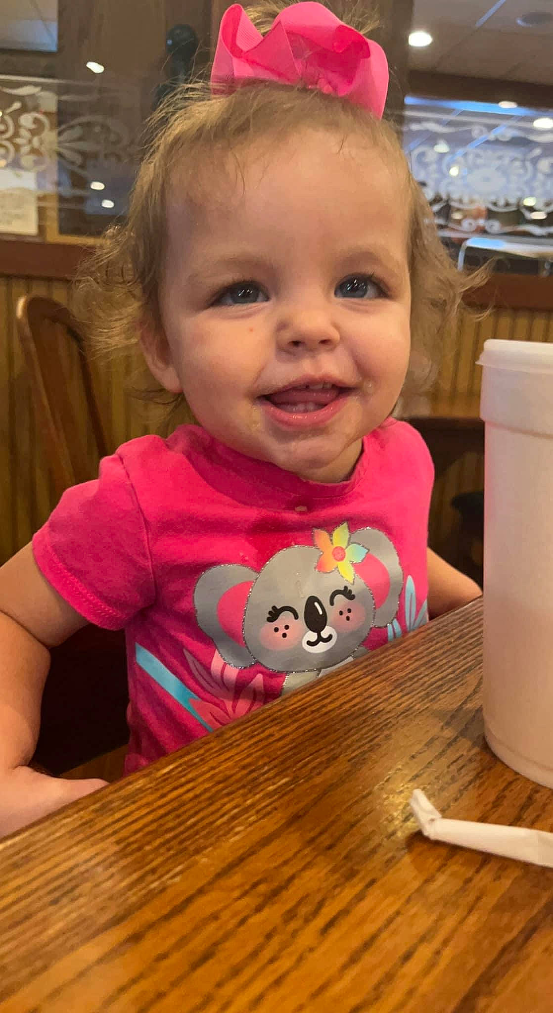 Aubrie is registered to the contest to win money with this photo: baby, baby_toddler_clothing, chair, cheek, child, cup, drinkware, face, fun, hairstyle, happy, joy, nose, person, pink, skin, smile, t_shirt, table, tableware