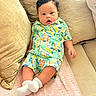Leyden is registered to the contest to win money with this photo: baby, child, infant, couch, pillow, cushion, clothing, colorful, pattern, socks, indoor, portrait, cute, relaxed, furniture, seated, young, face, skin, hair