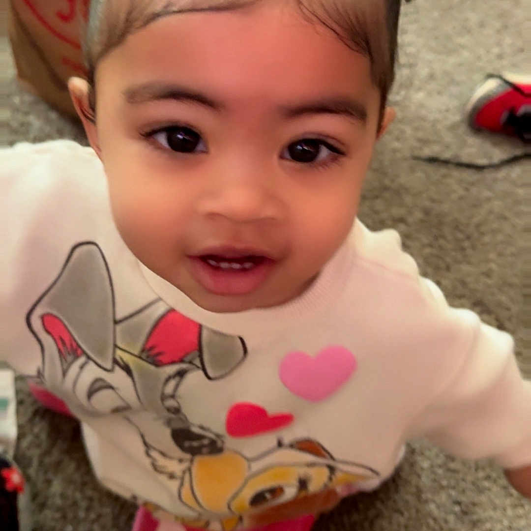 Joy joined the competition — help win amazing prizes! child, toddler, girl, pigtails, smiling, indoor, carpet, clothing, sweater, pink_pants, cute, face, hair, young_child, person, playful, home, floor, expression, casual