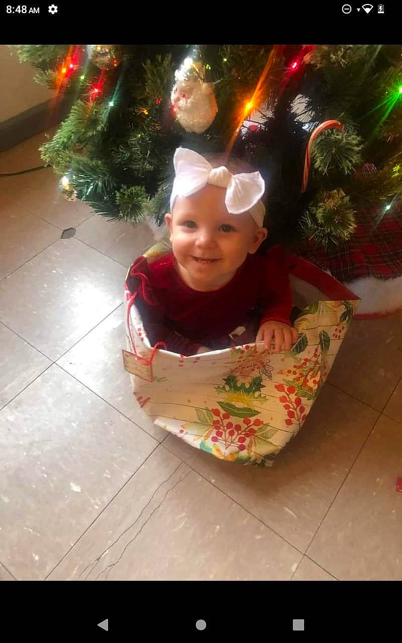 Adrieanna joined the competition — help win amazing prizes! baby, baby_toddler_clothing, christmas, christmas_decoration, christmas_ornament, christmas_tree, costume_hat, event, flooring, fun, happy, headwear, holiday, holiday_ornament, human_body, joy, light, ornament, person, plant