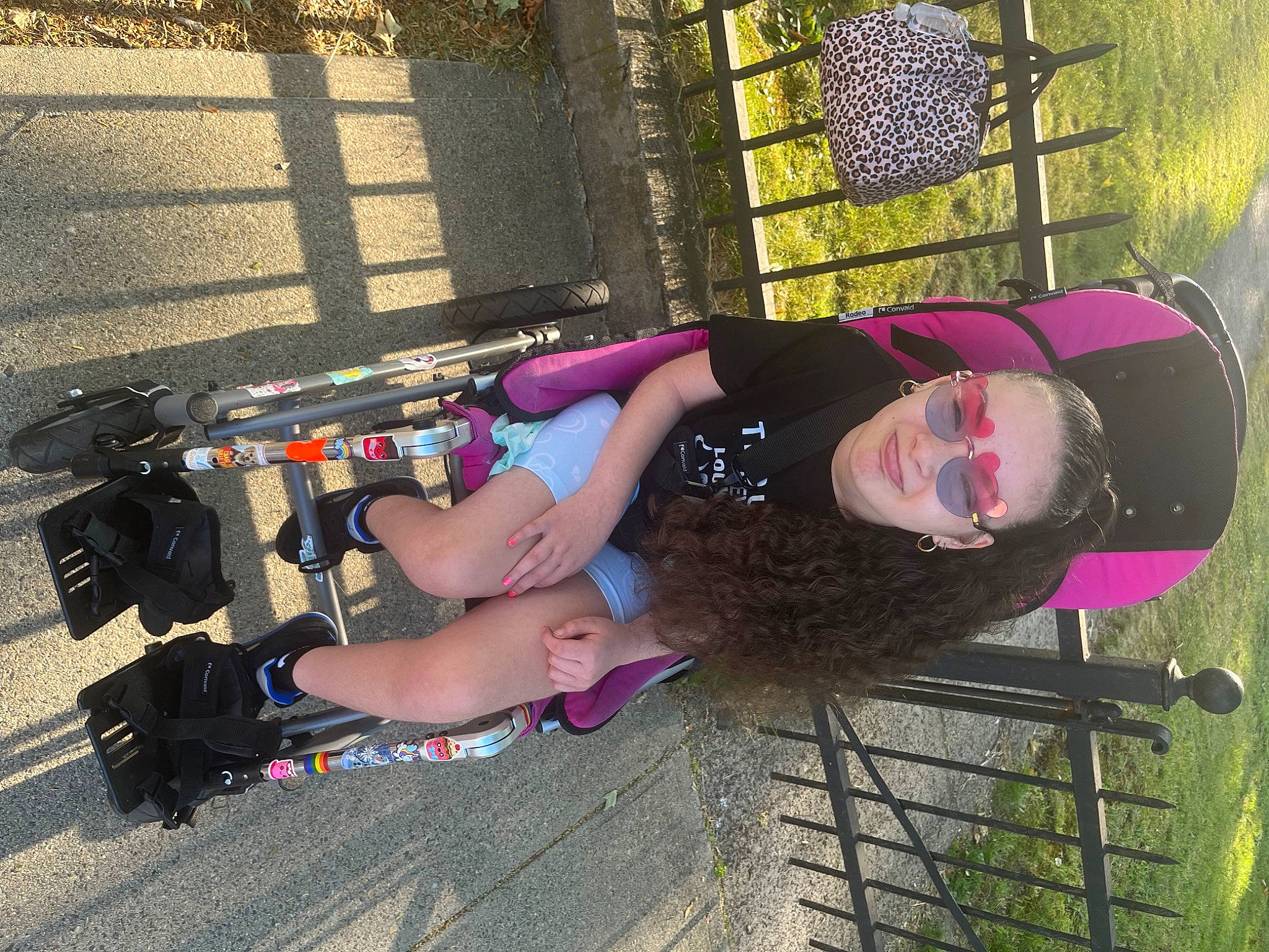 Samara is registered to the contest to win money with this photo: automotive_tire, bumper, eyewear, fun, grass, human_leg, joy, knee, leisure, magenta, person, recreation, sandal, smile, thigh, tire