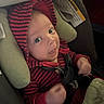 baby, infant, child, car_seat, secured, striped_outfit, hat, red, navy_blue, face, eyes, smiling, outdoor, vehicle, safety, seatbelt, cushion, portrait, close_up, photography