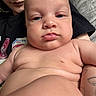 baby, infant, child, portrait, close_up, face, serious_expression, blue_eyes, bare_chest, adult, caregiver, tattoo, hugging, cuddling, dr_pepper, shirt, indoor, photography, family, humorous