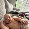 baby, sleeping, infant, child, portrait, couch, sofa, cushion, blanket, toy, indoors, window, sunlight, home, relaxed, peaceful, lying_down, diaper, skin, furniture