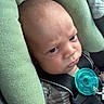 baby, infant, child, car_seat, pacifier, portrait, face, eyes, wide_eyed, sitting, indoors, vehicle, safety_harness, blanket, green, turquoise, close_up, head, baby_clothing, photography