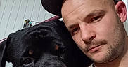 Nala Et Tyako a rejoint le concours — aidez-le/la à gagner de superbes lots ! man, dog, rottweiler, cap, selfie, indoor, portrait, pet, animal, face, closeup, headwear, chain_necklace, furniture, railing, wall, expression, casual, companion, friendship
