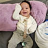 baby, infant, child, smiling, happy, portrait, sitting, lying_down, blanket, lavender, couch, clothing, onesie, pants, pacifier, toy, indoor, close_up, face, photography