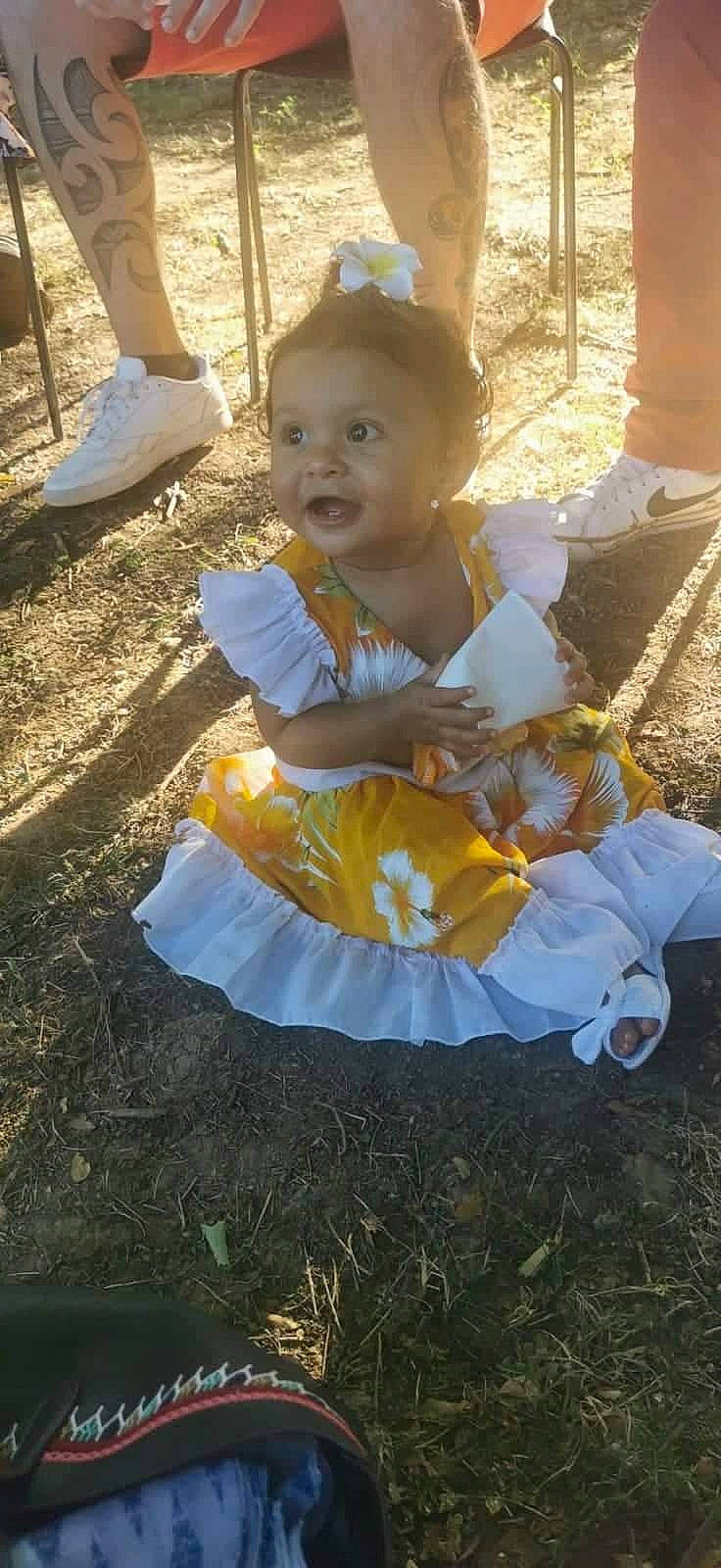 May-lee a rejoint le concours — aidez-le/la à gagner de superbes lots ! baby, baby_toddler_clothing, child, costume, event, eye, fun, grass, happy, hat, leisure, people_in_nature, person, plant, recreation, sitting, smile, soil, sunlight, toddler