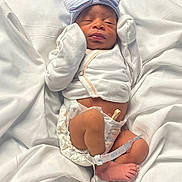 Kaiyonnie is registered to the contest to win money with this photo: baby, bed, birth, blanket, bow, closed_eyes, diaper, face, feet, gloves, headband, hospital, infant, lying_down, medical_bracelet, newborn, onesie, portrait, sleeping, white_blankets