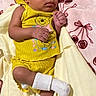 baby, bed, bedding, blanket, cherry_pattern, closed_eyes, crossed_legs, cute, face, family_photo, hands, indoors, infant, lying_down, newborn, photography, portrait, sleeping, socks, yellow_outfit