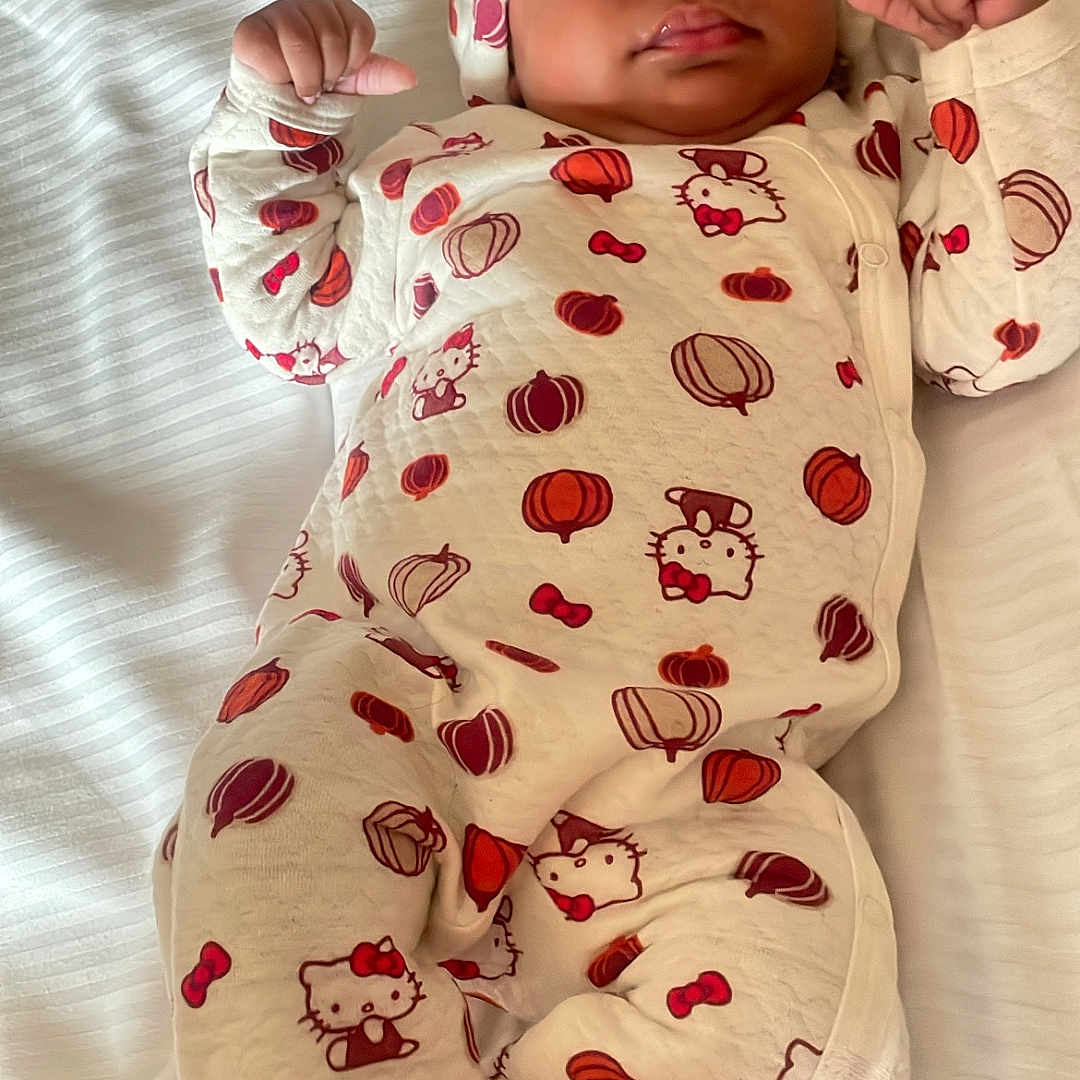 Kaiyonnie joined the competition — help win amazing prizes! arms, awake, baby, bed, bedding, bow, child, cute, face, fists, headwear, hello_kitty, indoors, infant, lying_down, onesie, pajamas, photography, portrait, pumpkin_pattern
