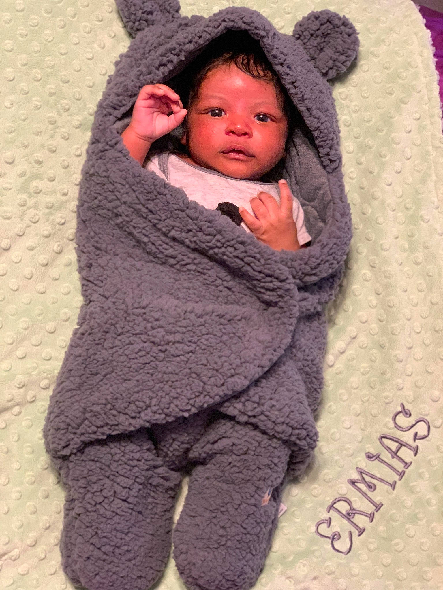 Ermias is registered to the contest to win money with this photo: baby, baby_toddler_clothing, cap, cheek, comfort, face, head, headgear, human_body, nose, outerwear, person, pink, product, purple, skin, sleeve, textile, toddler, wool