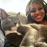 Goob joined the competition — help win amazing prizes! cat, person, smile, headphones, face_paint, blanket, couch, indoor, closeup, relaxed, feline, happy, fur, whiskers, yellow_eyes, casual, natural_light, nose_ring, piercing, cozy