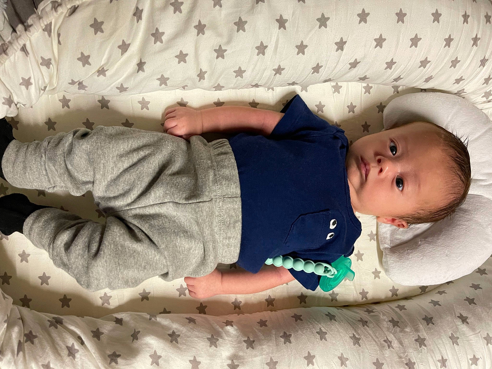 Emerson is registered to the contest to win money with this photo: arm, baby, baby_products, baby_sleeping, baby_toddler_clothing, child, comfort, hand, human_body, linens, pattern, person, room, sitting, skin, sleeve, sock, textile, toddler, white