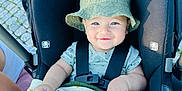 Logan joined the competition — help win amazing prizes! baby, child, smiling, stroller, bucket_hat, pacifier, blanket, cheetah_pattern, outdoor, daylight, cobblestone, infant, cute, happy, seated, clothing, person, baby_accessory, headwear, straps