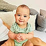 Logan joined the competition — help win amazing prizes! baby, infant, child, smiling, onesie, sitting, hands, face, eyes, cheeks, skin, person, couch, pillow, home, indoor, cute, happy, family, comfort