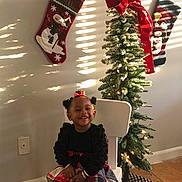 Anyla is registered to the contest to win money with this photo: architecture, baby, building, christmas, christmasdecorations, clothing, face, festival, gift, head, hosiery, indoors, lighting, person, photography, plant, portrait, pottedplant, sock, tree
