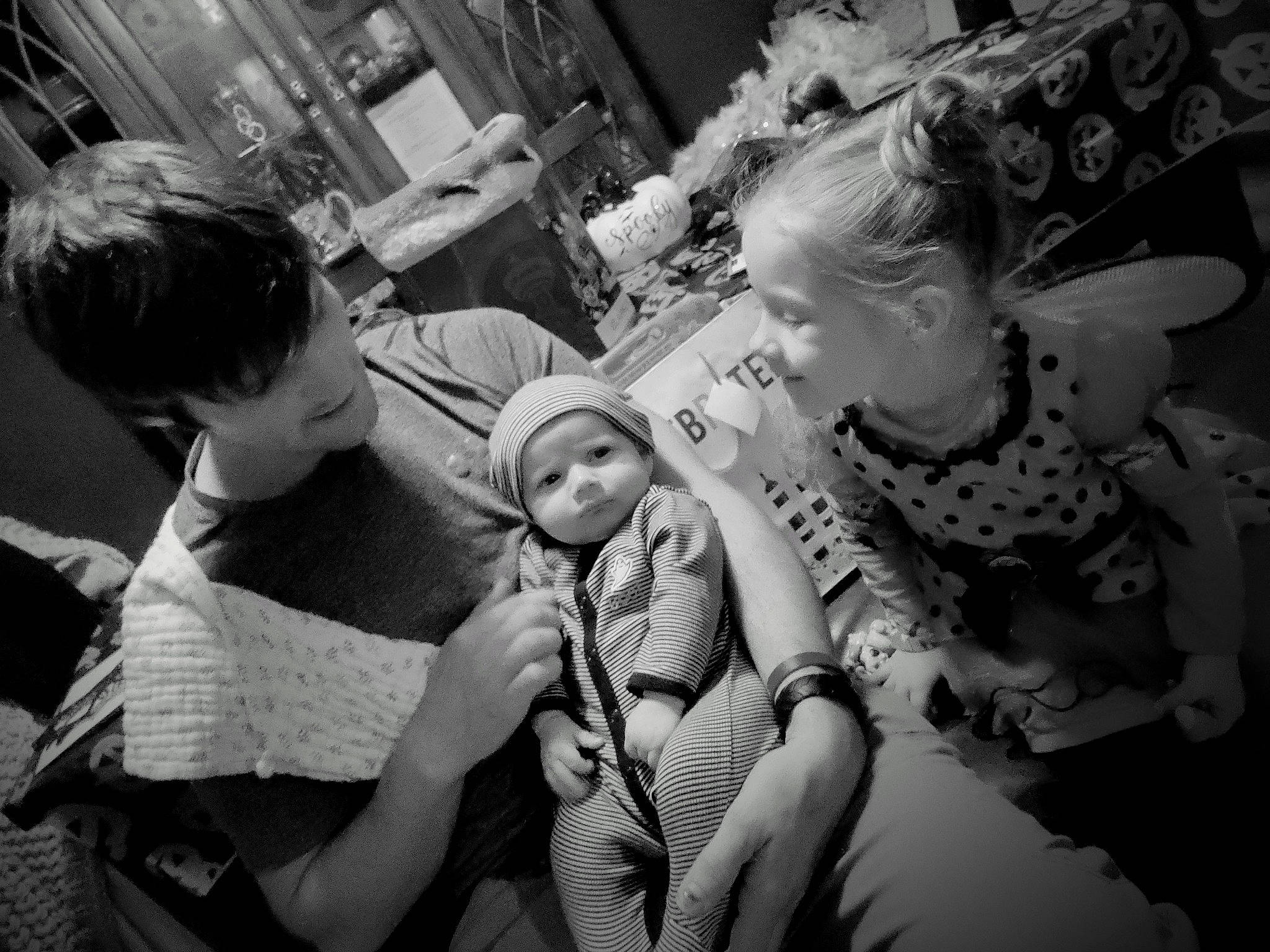 Ryker joined the competition — help win amazing prizes! baby, black_and_white, child, comfort, event, facial_expression, fun, gesture, hairstyle, happy, headwear, interaction, jewellery, monochrome, monochrome_photography, pattern, person, room, sitting, street